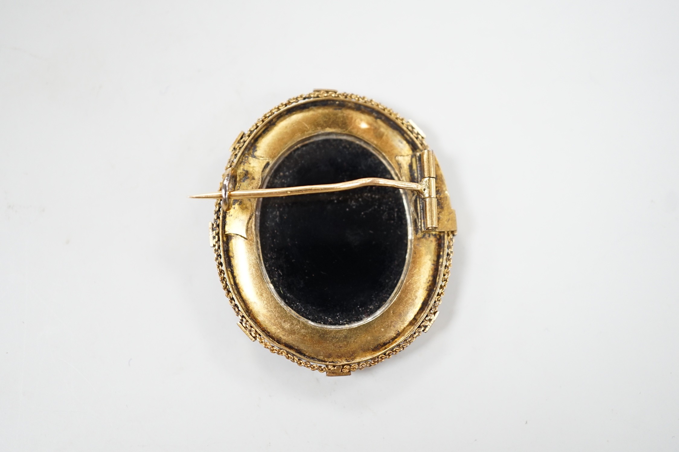 A Victorian canettile work yellow metal and sardonyx? cameo and split pearl set oval brooch, carved with Erato, 38mm, gross weight 8.5 grams.